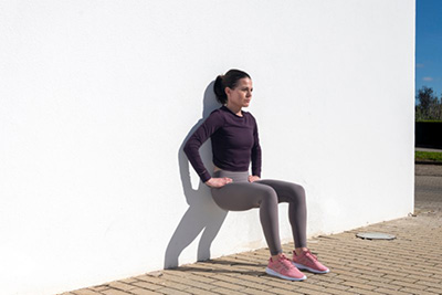 Mujer haciendo ejercicios para esclerosis múltiple de fuerza para el tronco inferior